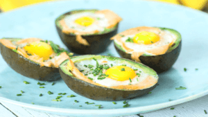 Gevulde avocado met zalm en ei op wit schaaltje