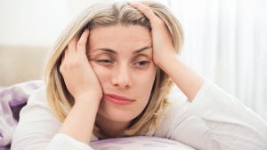 Vermoeide vrouw ligt op bed