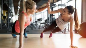 Sportende vrouwen geven elkaar een high five op de grond