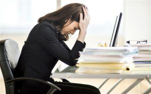 vrouw ervaart stress achter haar laptop