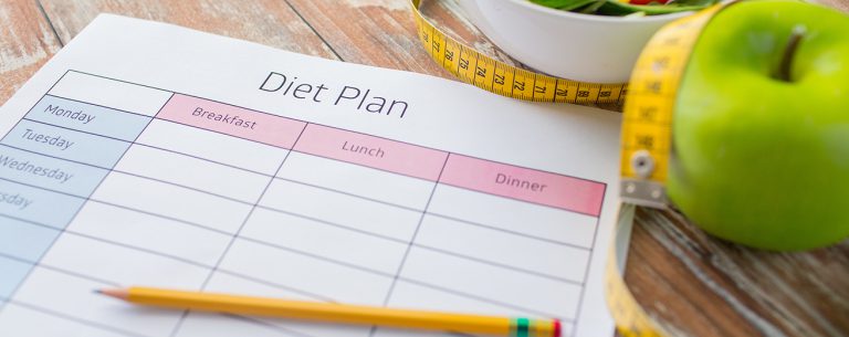 Close-up van dieetplan en eten op tafel