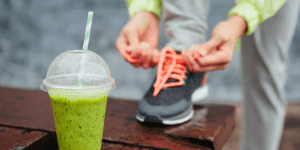 persoon strikt veters met op de voorgrond een groene smoothie