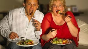 Gezellig koppel zit samen te eten op de bank 