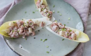 Pittige garnalensalade met witlof op bord