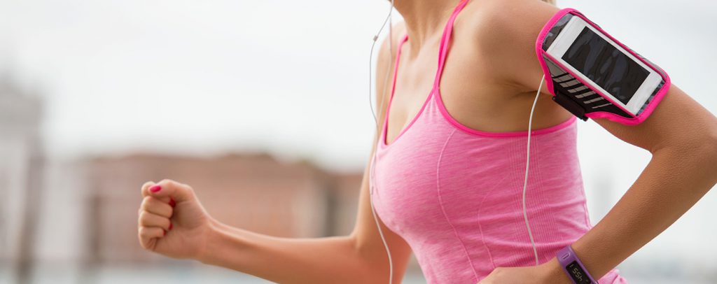 hardlopende vrouw met sportapparatuur om arm