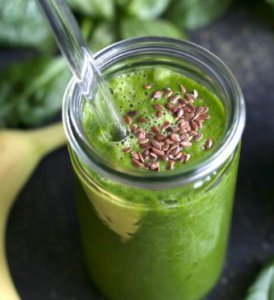 close up van groene smoothie met gebroken lijnzaad