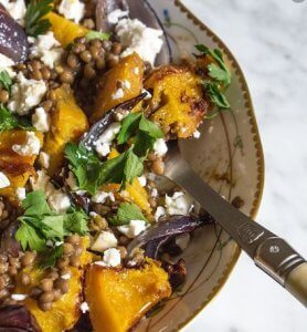 Pompoen gevuld met linzen en feta op een bord