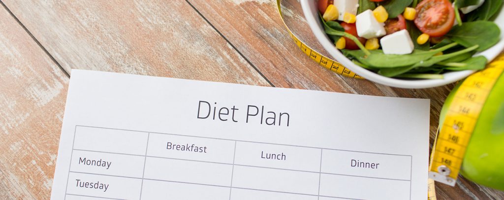 close-up van dieetplan en eten op tafel