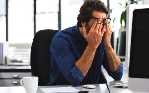Vermoeide man achter zijn bureau